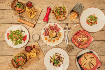 set of dishes of various nationalities on rough wooden table with forks