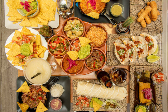 set of mexican dishes with nachos, tacos, quesadillas, wire, tequeños, guacamole, pico de gallo, tamal