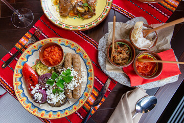 Nicely served assortment of roasted juicy vegetables and kebab with sauce and cheese feta in restaurant