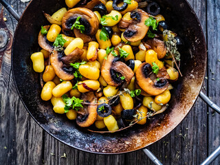 Gnocchi with fried white mushrooms on wooden table

