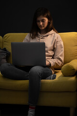 upset Attractive long-haired brunette girl sitting thoughtfully on couch with laptop getting...