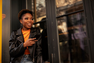 Young african woman using the phone. Beautiful woman typing a message.