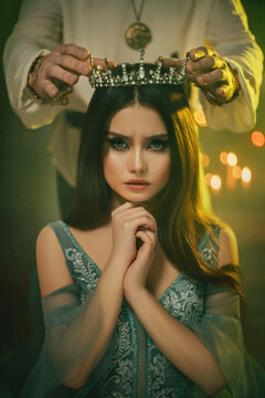 Fantasy medieval couple. Image of lovers - king and queen. hands of man put gothic crown on girl's head. Coronation of woman. vintage costume clothing. Portrait close up girl princess beauty face.