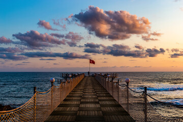 Wooden pier and sunset over sea.