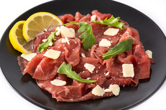 Marbled beef carpaccio on black plate isolated on white background