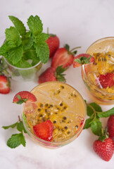 the passion fruit cocktail with mint and ice cubes in glass, homemade fresh fruit, passion and strawberry  sweet fruit drinks, fruit drink for healthy concept, selective focus.