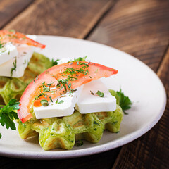 Delicious homemade spinach vegetarian  waffles with feta cheese and tomatoes.