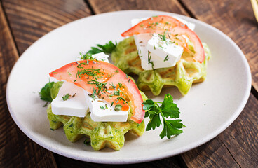 Delicious homemade spinach vegetarian  waffles with feta cheese and tomatoes.
