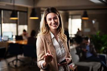 Businesswoman in office. Smiling beautiful businesswoman using the phone.