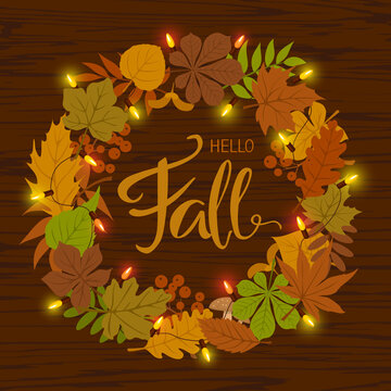 autumn fall leaves wreath with festive light balb garland and handwritten text