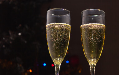 Champagne glasses on the background of a decorated Christmas tree. The concept of a holiday, New Year.