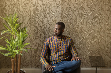 Black African business entrepreneur sitting against patterned wall