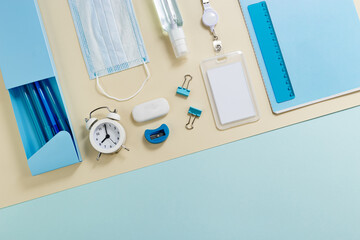 Flat lay with stationery for study and work, face mask and sanitizer Back to school concept.