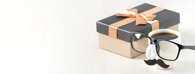 Father's day design concept. Close up of cup of coffee and gift box for daddy.