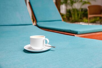 The coffee mug placed on the sanbed has a blue Seat cover