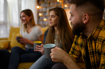 A group of friends hanging out on a house party and drinking coffee