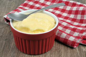 Ramequin de crème avec une serviette à carreaux en gros plan sur fond en bois