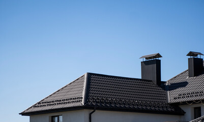 Brown corrugated metal profile roof installed on a modern house. The roof of corrugated sheet. Roofing of metal profile wavy shape. Modern roof made of metal. Metal roofing.