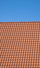 Red corrugated metal profile roof installed on a modern house. The roof of corrugated sheet. Roofing of metal profile wavy shape. Modern roof made of metal. Metal roofing.