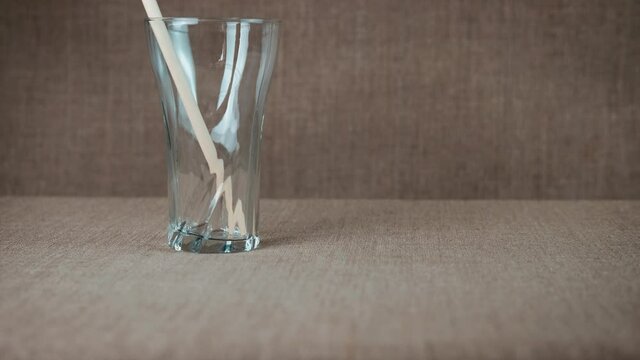 Drinking straw for family. Somebody takes a straw from the glass for drinking in the room.