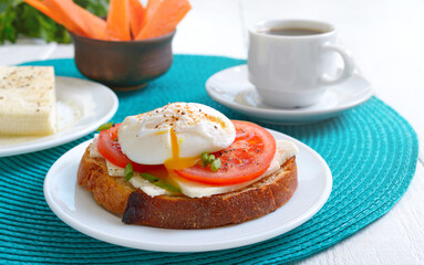 Sandwich with poached egg and coffee.