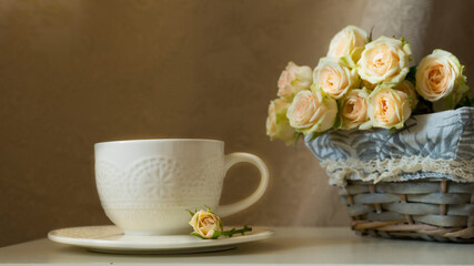 Beautiful white cup and tea roses in a basket. Image with selective focus