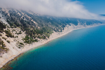 Aerial view of coastline with blue sea and cliffs with clouds. Summer day on sea