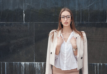 Obraz premium Beautiful fashion stylish woman on the wall city background