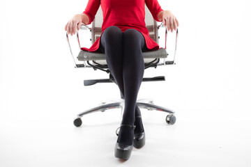 Close-up of the legs of a woman in pantyhose who is sitting on an office chair
