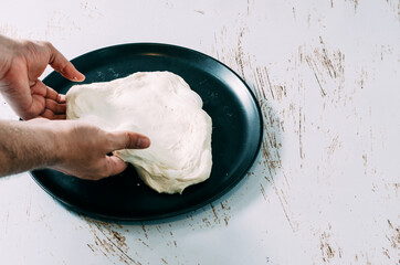 Chef making homemade pizza by rolling out pizza dough