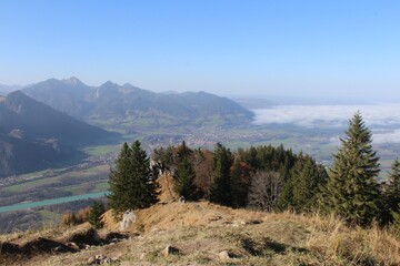 Fototapeta na wymiar Aussicht von einem Berg in den Alpen mit Bäumen und Wolken 