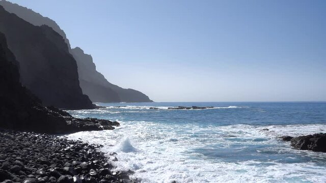 Blaues Meer mit Wellen an steiler vulkanischer Felsenk&uuml;ste - Playa del Trigo bei Alojera, La Gomera, Kanarische Inseln