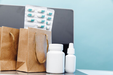 Online medical shopping concept. Paper bags with prescription drugs and pills and conteiners on laptop