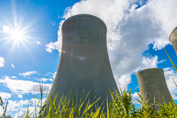 Close-up shot of a cooling tower of nuclear power plant behind green grass. In a beautiful sunny...