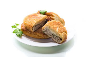 fried pies with meat in a plate on a white