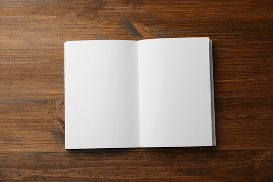 Open blank paper brochure on wooden table, top view. Mockup for design