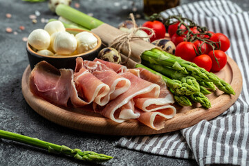 Fresh prosciutto with mozzarella cheese and cherry tomatoes. Ingredients for tart, pizza or pie