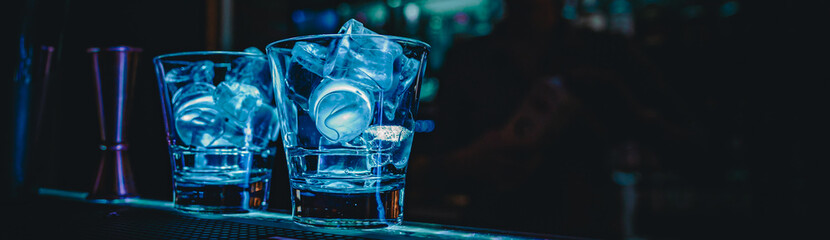 Ice cube in an empty glass on a bar counterin bar or pub