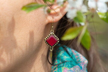 Close up of woman ear wearing beautiful earrings with mineral gemstone