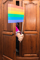 unknown person hand coming out of closet with gay pride flag. come out of the closet. Lgbt...