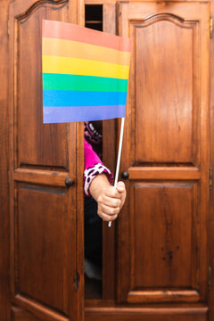 unknown person hand coming out of closet with gay pride flag. come out of the closet. Lgbt community concept. selective focus.