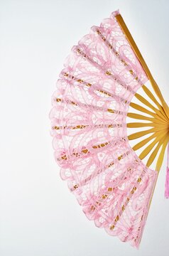 Wooden Fan With Pink Natural Fabric On A White Background