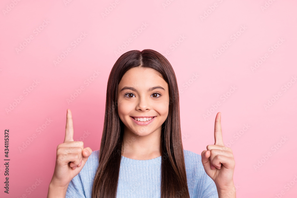 Wall mural Portrait of attractive cheerful girl pointing forefingers up copy empty space ad isolated over pink pastel color background