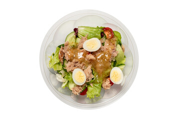 Fresh tuna salad with lettuce, cucombers, cherries and eggs in plastic container.