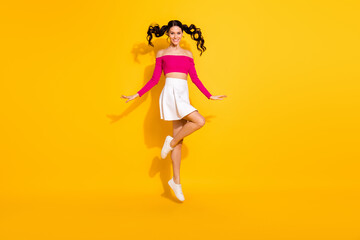 Full size photo of optimistic lovely brunette lady jump wear pink top skirt isolated on yellow background
