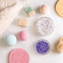 Bathing products on a white background. A set of salt, soap, bath bombs, washcloths. View from above