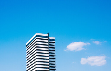 one skyscraper white building rises sky clouds