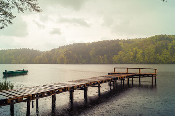Drewniany pomost nad jeziorem w Łapinie w deszczowy dzień. © Szczepan Buśko