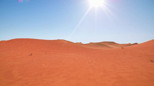 Camera is flying through a red desert - timelapse video, following the path of the sun