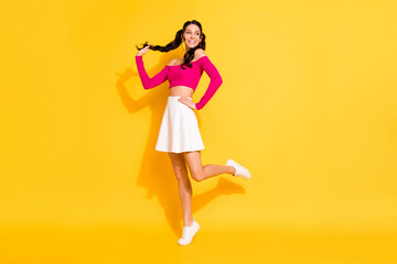 Fototapeta na wymiar Full length body size view of attractive cheerful thin wavy-haired girl posing having fun good mood isolated over bright yellow color background